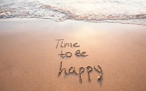 The feeling after a guided meditation class: seeing the words "Time to be happy " written in the sand on a beach