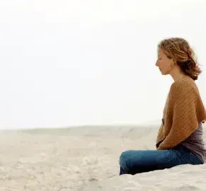 Woman meditating on the beach